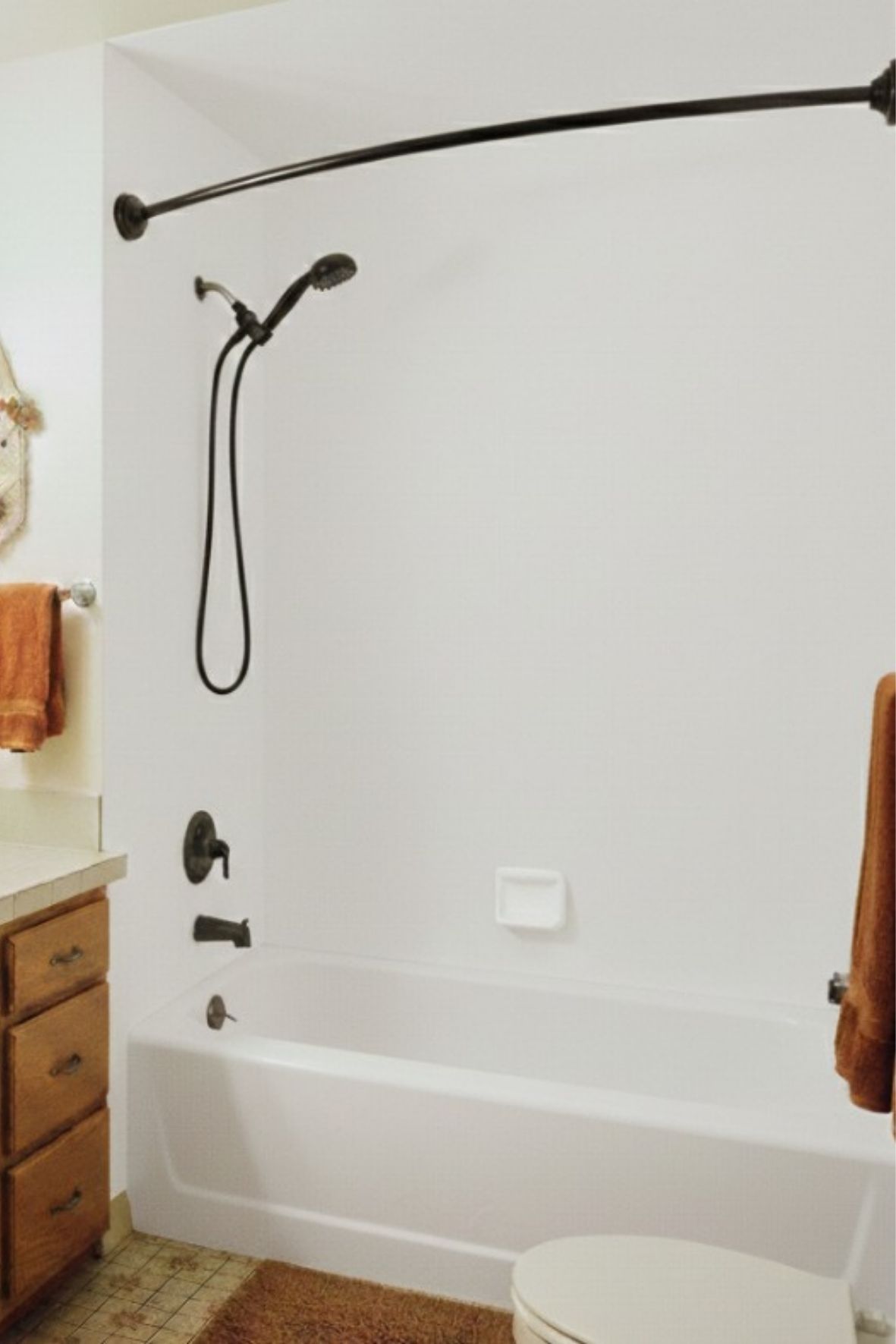 baignoire blanche avec robinetterie noire dans un espace de salle de bain simple  à Val-des-Sources